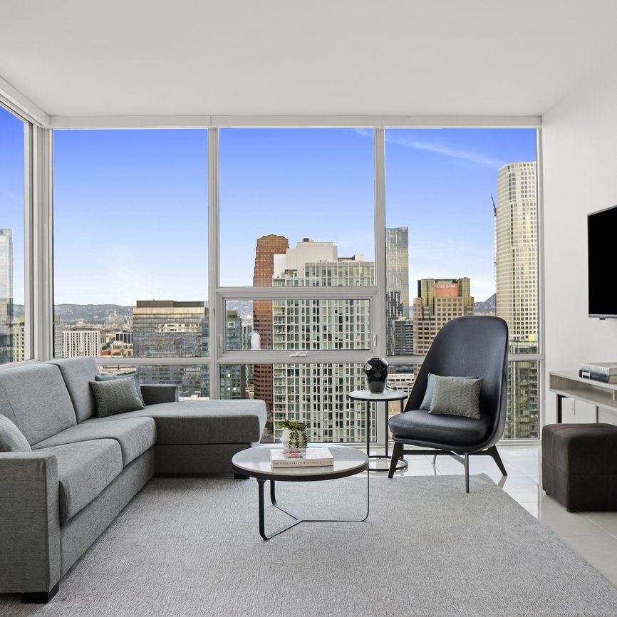 living room with a view of the LA skyline in a two bedroom suite at Level Los Angeles South Olive