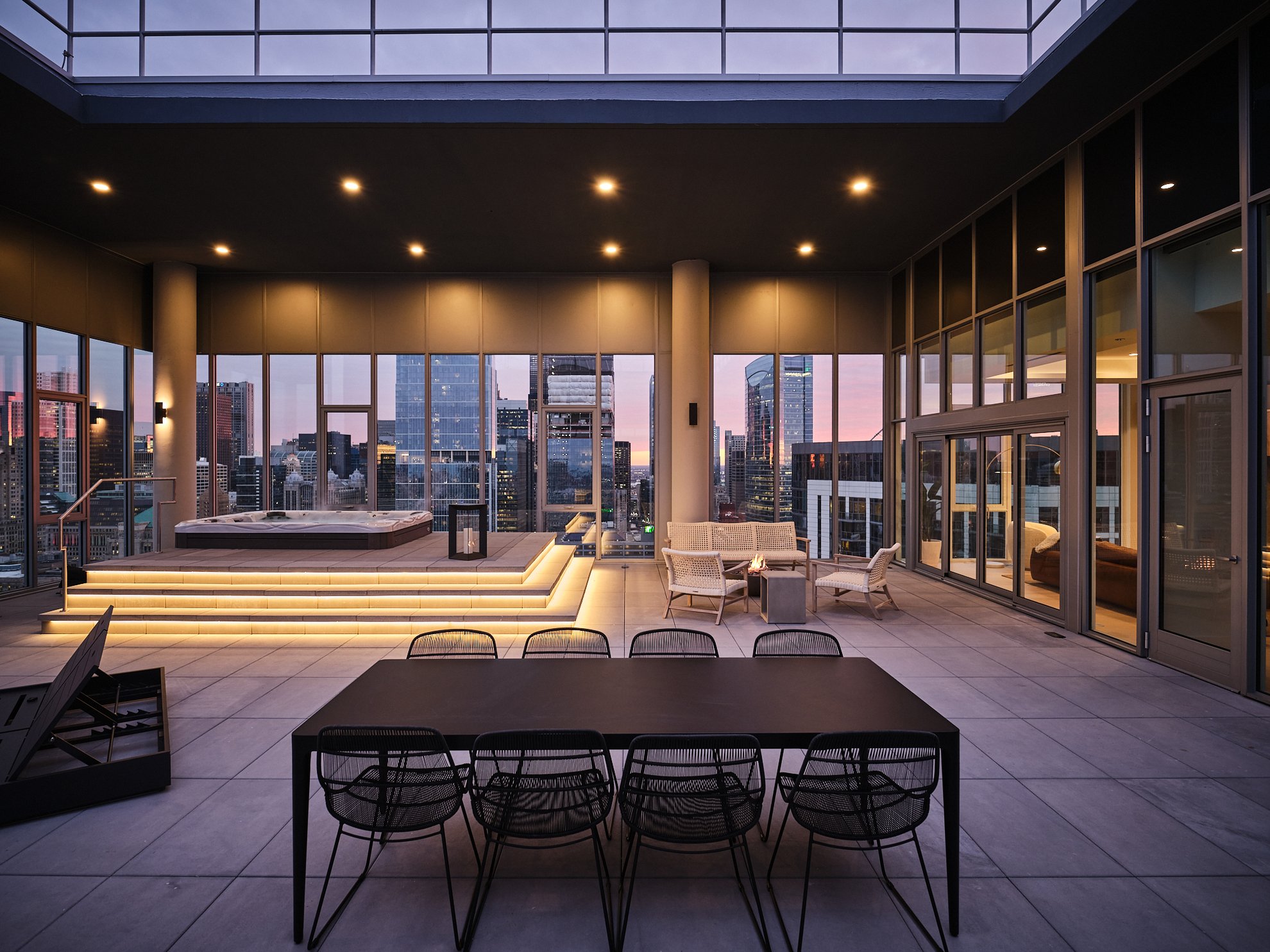 the penthouse level chicago river north spacious outdoor patio with different seating areas as well as the hot tub looking over chicago city view