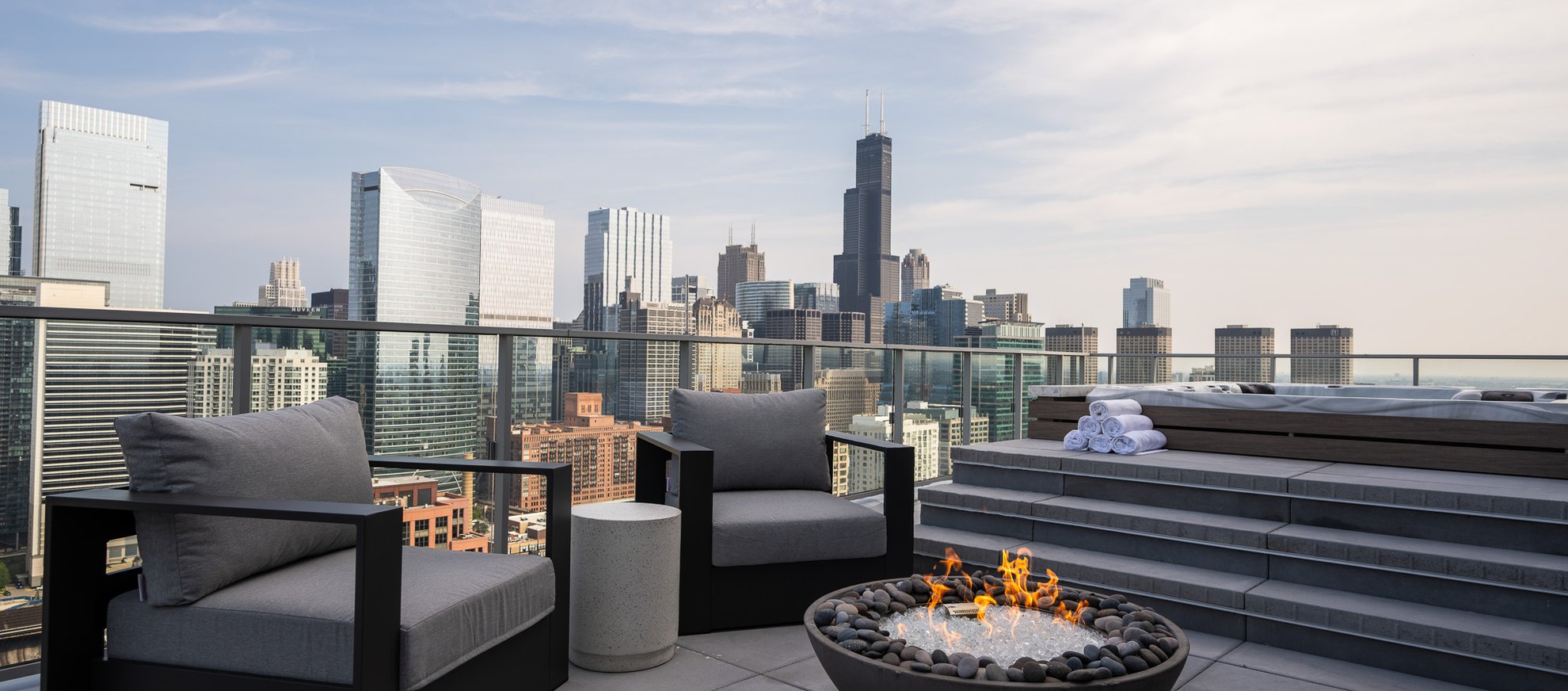 outdoor fire place and hot tub at the penthouse level chicago fulton market looking over chicago city view