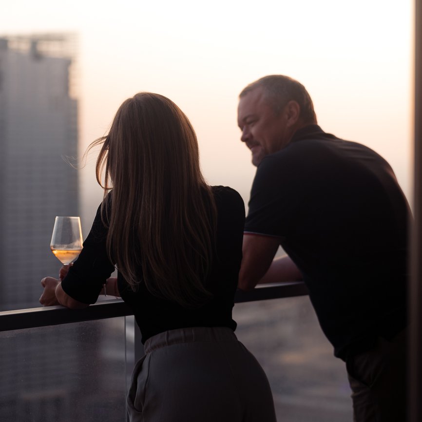 couples drinking wine on the balcony with dtla skyline