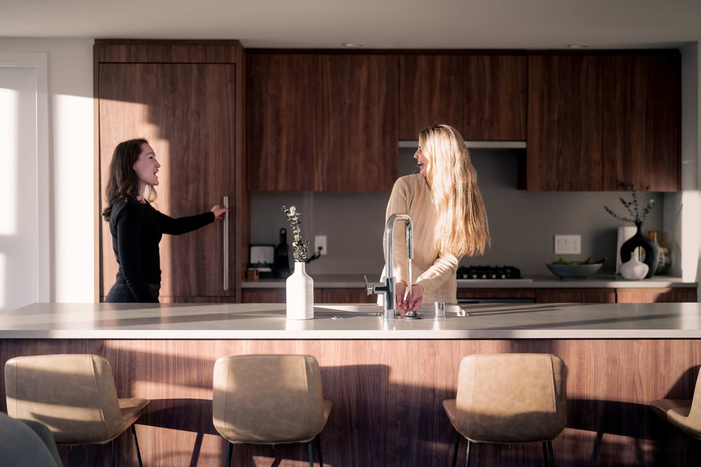 two women chatting in the kitchen of a suite at level seattle south lake union