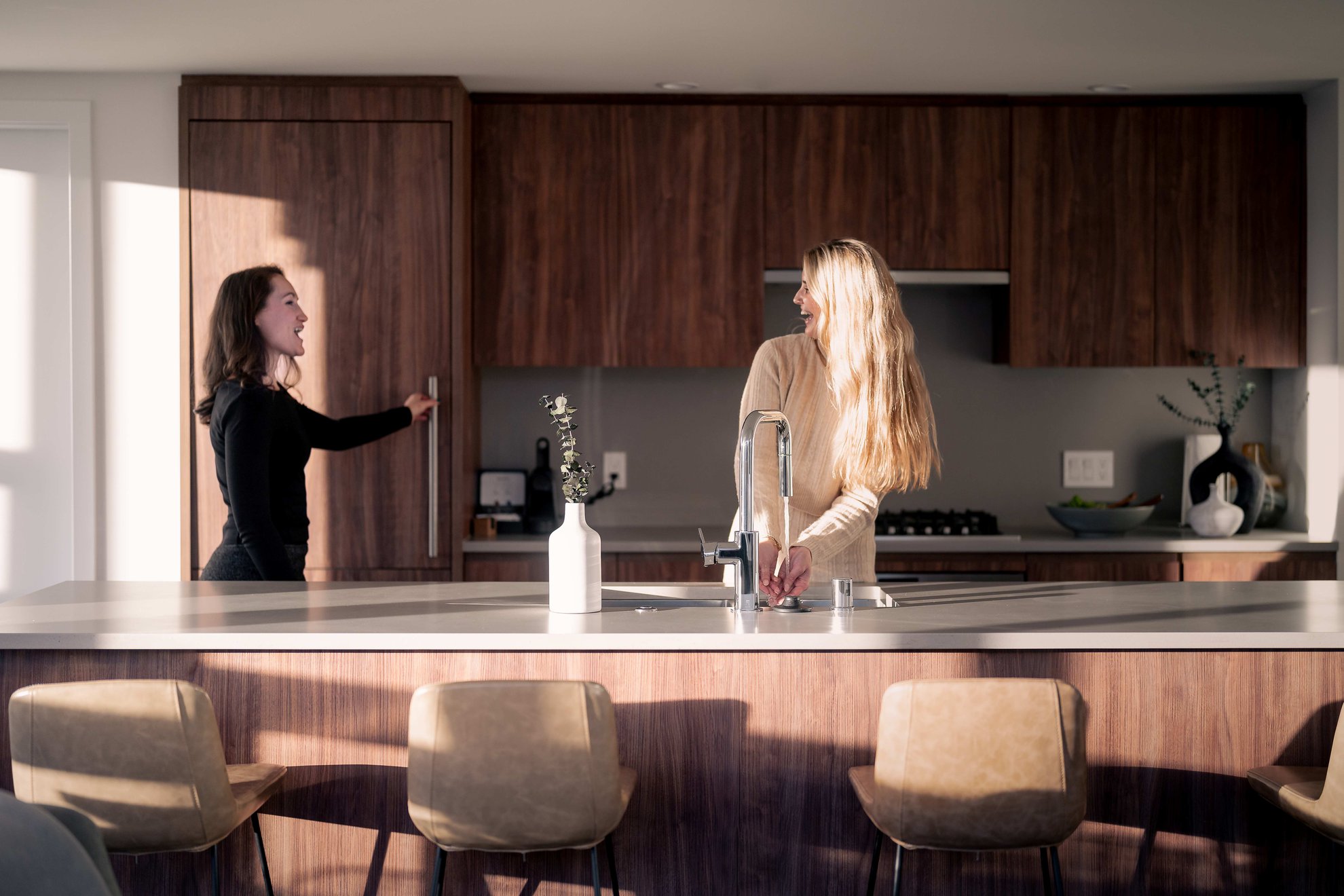 two women chatting in the kitchen of a suite at level seattle south lake union