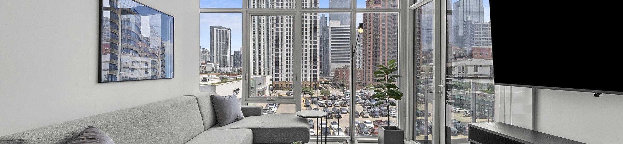 junior two bedroom suite features living area with tv mounted on the wall with beautiful chicago city view at level chicago fulton market