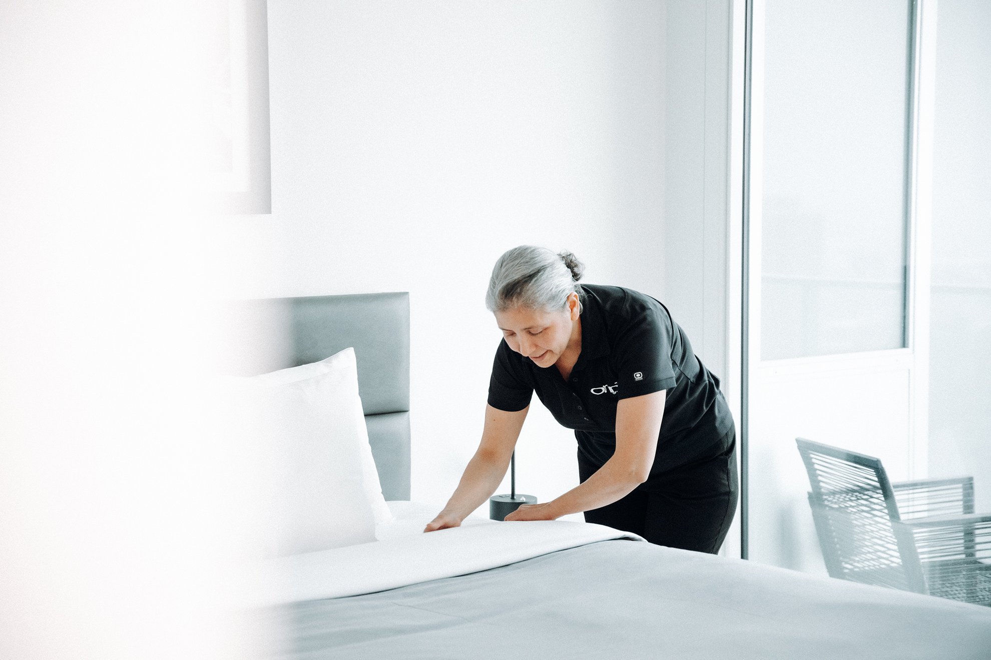 housekeeper tidying up the room at level hotels furnished suites
