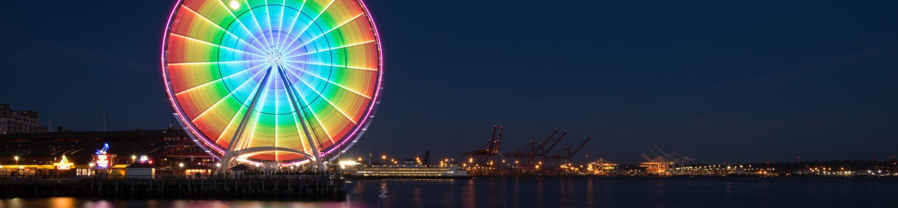 The Ferris wheel in Seattle lit up in rainbow colors for Seattle Pride month celebrations