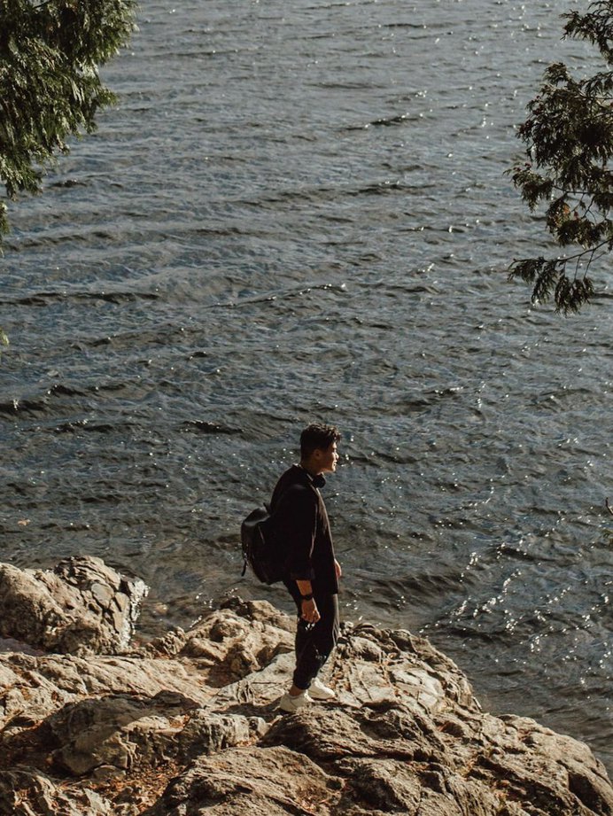 Man standing on rocks in front of Buntzen Lake in Port Moody