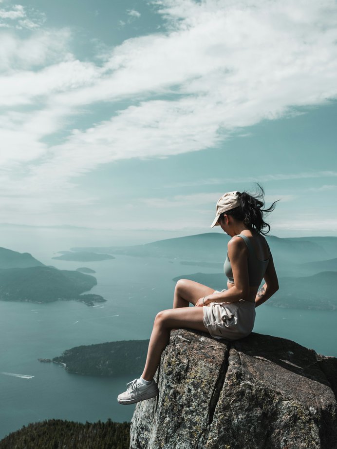 Girl sitting on top of St. Mark's Summit, 45 minutes driving from Level Vancouver