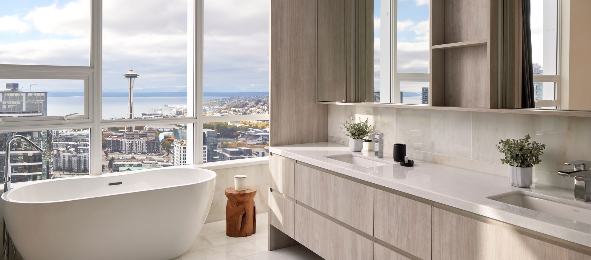 spacious elegant bathroom features white bathtub near large window with space needle seattle city view at level seattle south lake union the penthouse.jpg